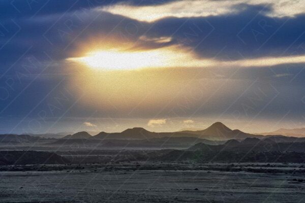 sun piercing through the clouds over a Karoo landscape