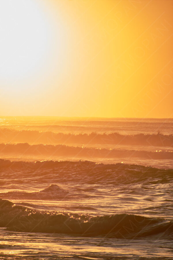 orange haze as the sun rises over the ocean